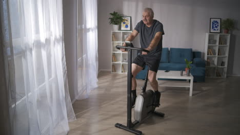Heimfitness-Mit-Stationärem-Fahrrad-Cardio-Training-Für-Die-Gesundheit-Der-Atmung-Und-Des-Herz-Kreislauf-Systems-Ein-Mann-Mittleren-Alters-übt-Sportliche-Aktivitäten-Aus